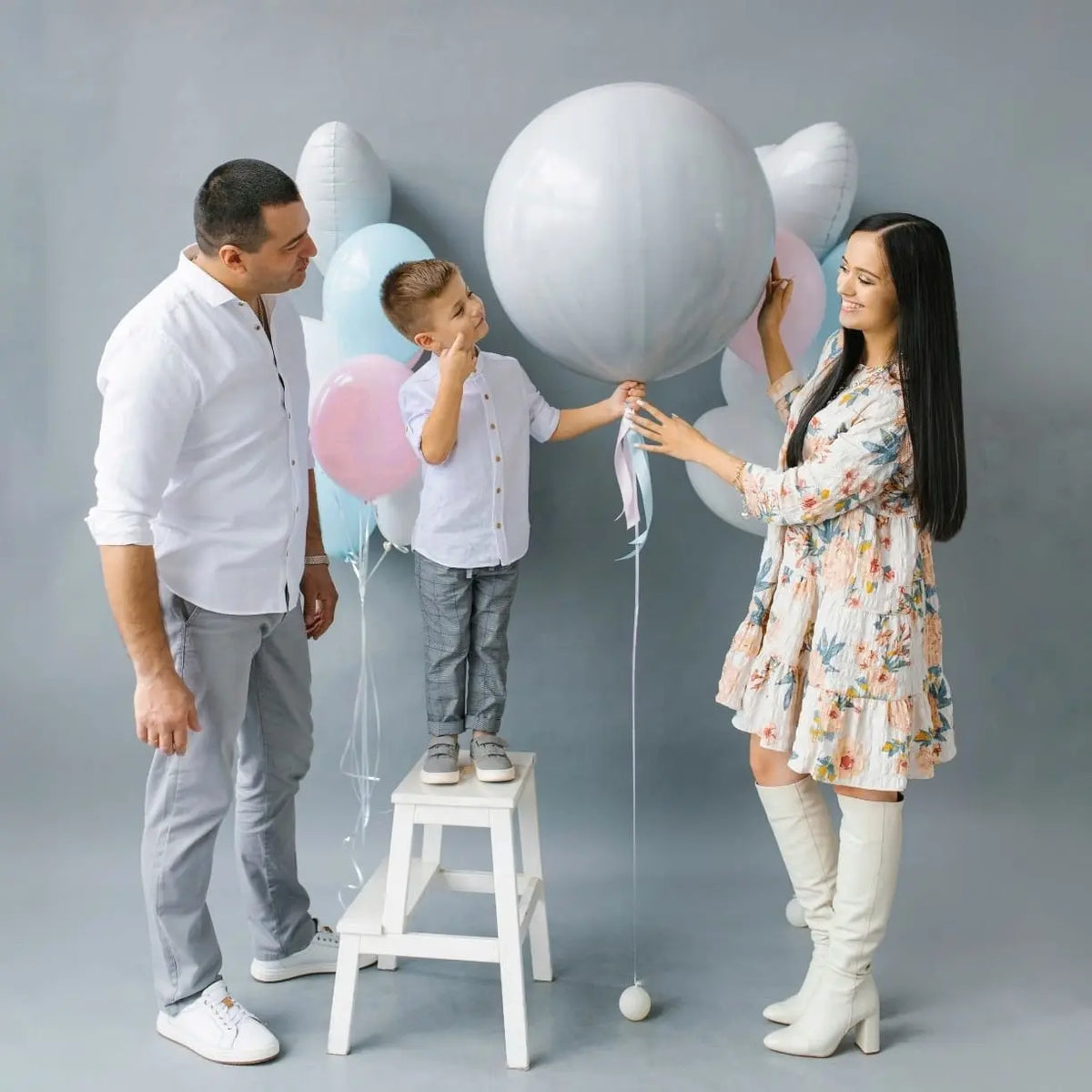 Revelación del Sexo del Bebé con globos para revelar género coloridos, incluyendo confeti rosa y azul en una divertida celebración.